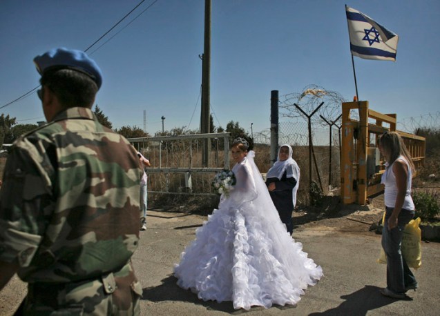 Israeli-Druze bride Arin Safadi, 24, departs through the United Nations buffer zone at the Quneitra crossing in the Golan Heights, which Israel captured from Syria in 1967, to marry a Syrian-Druze groom, Thursday, Sept. 25, 2008. Once crossing into Syria, the bride is not allowed to go back to Israel. Syria and Israel have held four rounds of indirect talks through Turkish mediation so far and Assad recently said he is looking to have direct, face-to-face talks next year. The main sticking point has been the extent of an eventual Israeli withdrawal from the Golan Heights. The issue led to the collapse of U.S.-brokered direct negotiations in 2000. Syria demands the complete return of the Heights. Israel has sought to keep a strip of land around the Sea of Galilee. ©Dan Balilty | AP