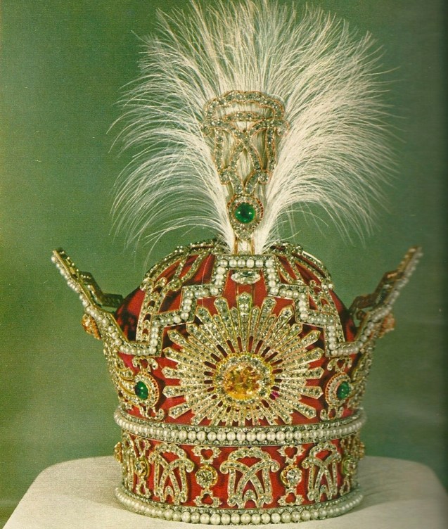 “The Pahlavi Crown was commissioned and first used for the coronation of Reza Shah on 25 April 1926. It was used for the last time during the coronation of his son and successor Mohammad Reza Shah Pahlavi on 26 October 1967. (…) The frame of the crown is made of gold, silver and red velvet. It has a maximum height of 29.8 cm, a width of 19.8 cm and weighs nearly 2,080 grams. A staggering 3,380 diamonds, (1,144 carats), are set into the object. The largest of these is a 60-carat (12 g) yellow brilliant, which is centrally placed in a sunburst of white diamonds. Found in three rows are 369 nearly identical natural white pearls. The crown also contains five emeralds (totalling 200 carats), the largest of which is approximately 100 carats and located on the apex of the crown.” © All Rights Reserved