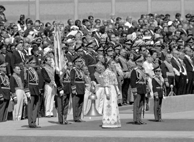 During the celebrations to mark the 2,500 anniversary of the founding of the Persian Empire, The Shah of Iran, second right, Crown Prince Riza, right, and Empress Farah, third right, watch the laying of a wreath laying ceremony at Pasargadae, Iran, Oct. 12, 1971. (AP Photo) # Farah Diba disse sim ao Xá no dia em que completou 21 anos, a 14 de Outubro de 1959. O noivado foi oficialmente anunciado a 21 de Novembro. O casamento celebrou-se a 21 de Dezembro. Yves Saint-Laurent, da casa Dior, desenhou-lhe o vestido bordado com fios de prata. O diadema para a cabeça era jóia do Estado. Concebido pelo americano Harry Winston, pesava dois quilos. @DR (Direitos Reservados | All Rights Reserved) 