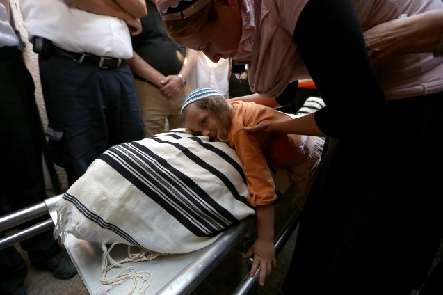 The son of the Jewish settler Eviatar Borovsky touches the body of his father during his funeral at the village of Kfar Hasidim, near Haifa, Israel, 30 April 2013. Borovsky was allegedly stabbed to death by a Palestinian Fatah operative from a village near Tulkarem earlier on 30 April at the Tapauch Junction in the northern West Bank. @EPA/ABIR SULTAN