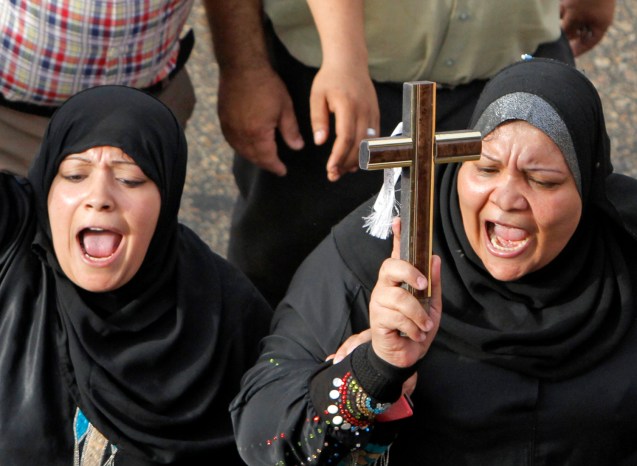 Egyptian Muslim women hold a cross in support of Christians during a memorial march in Cairo for Christians who were killed during deadly clashes with Muslims in April. ©Amr Nabil / AP file 