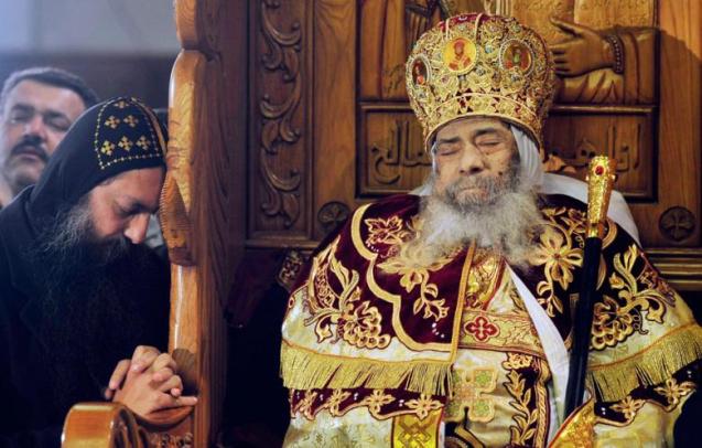 Oração de um copta junto ao corpo do Papa Shenouda III, líder da Igreja Copta Ortodoxa do Egipto, exposto ao público para as devidas homenagens, na catedral de Abbasiya no Cairo (18 de Março de 2012). © Esam Al-Fetori | Reuters