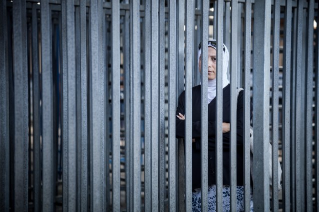 Nibal Raj, palestiniana, 42 anos, viúva, uma só filha, formada em Sociologia da Educação, co-directora do Sulha Project, com a israelita Dafna Schwartz: “Às sextas-feiras, os soldados só nos deixam passar no checkpoint de Qalandiya - na foto - , que ela atravessa diariamente] depois das orações nas mesquitas em Jerusalém. Os militares têm medo da violência que escape ao seu controlo, e estão confusos. Não nos conhecem. É difícil destruir o muro interior que nos divide.” © Udi Goren