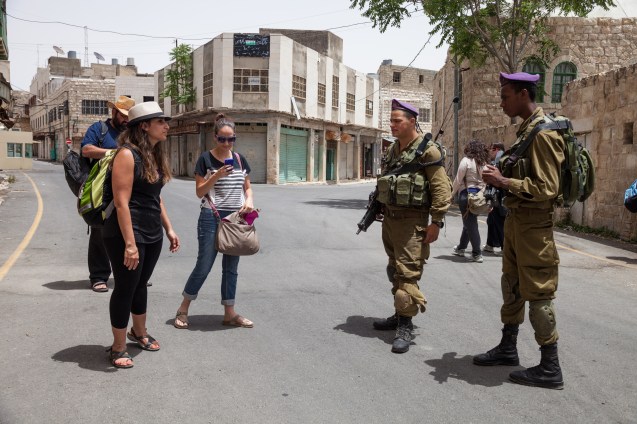 Gil Hilel and Adi Mazor with Yehuda Shaul, (co-founder of Breaking the Silence (BS), an organization that tries to encourage Israeli society to set itself free from the occupation. They are explaining to border policemen on duty in Hebron that their testimonies are the way they have found to better express their “love for Israel”. @ Udi Goren