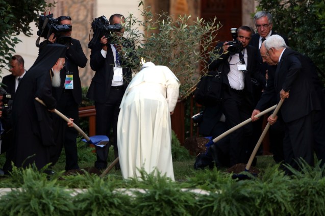 Pope Francis (3rd R), Israeli President Shimon Peres (2nd R), Palestinian President Mahmoud Abbas (R) and Patriarch Bartholomaios I plant an olive tree during a peace invocation prayer at the Vatican Gardens on June 8, 2014 in Vatican City, Vatican. Pope Francis invited Israeli President Shimon Peres and Palestinian President Mahmoud Abbas to the encounter on May 25th during his brief but intense visit to the Holy Land. © Franco Origlia/Getty Images)