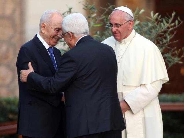 O abraço do palestiniano Mahmoud Abbas ao israelita Shimon Peres, perante o olhar do Papa Francisco, durante a “oração pela paz” em Junho de 2014, nos jardins do Vaticano. © nbcnews.com 