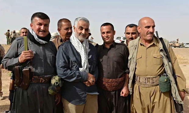 Qassem Suleimani (centre, with revolutionary scarf), the commander of the elite Revolutionary Guards Quds force, poses with a group of peshmerga fighters in Kurdistan. © IRNA | The Guardian