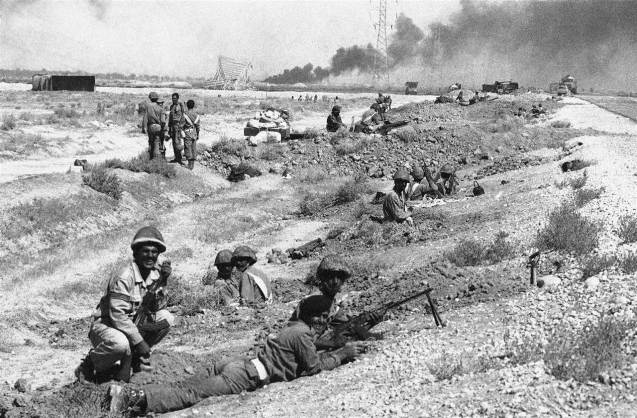 September 22, 1980: Iraq invades Iran, leaving Iran diplomatically isolated from the West, supporting Iraq, for the better part of the decade. A cease-fire wasn't declared until 1988, after an estimated 1 million lives were lost. Above: Iraqi troops entrenched along the highway connecting Abadan with Khorramshahr on Oct. 19, 1980 while smoke drifting in background comes from an oil refinery near Abadan, which was set by Iraqi artillery bombardment. © NBC News