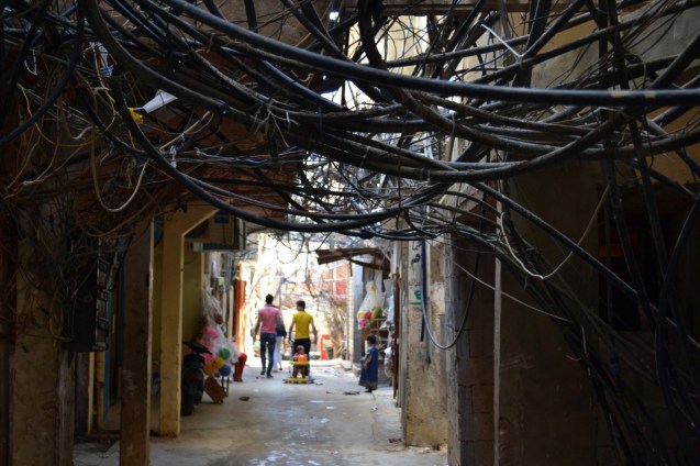 An alleyway in the Bourj al-Barajneh Palestinian refugee camp in Beirut, Lebanon where jumbled electricity and water cables run over cramped streets. © Caroline Anning | The Washington Post
