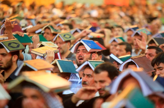 Shi'ite Muslims place copies of the Koran on their heads during a ceremony marking the death anniversary of Imam Ali at his shrine in the holy city of Najaf, about 160 km (100 miles) south of Baghdad © Ahmad Mousa | Reuters 