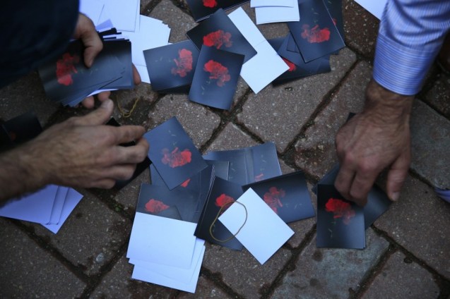 Fotos com cravos vermelhos foram usadas nas manifestações de homenagem às vítimas do Daesh em Ancara © Lefteris Pitarakis | AP