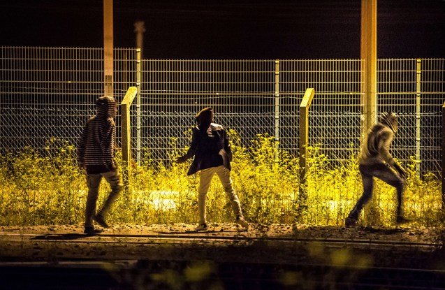 Migrants that have passed a first fence look for another passage to access the Eurotunnel terminal on August 6, 2015 in Frethun near Calais, northern France © Philippe Huguen | AFP | Getty 
